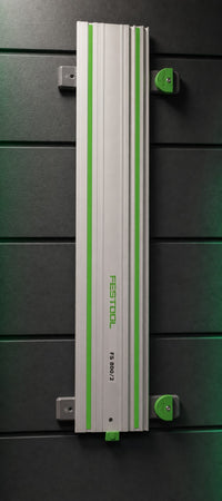 02 — CamDock™ storing one Festool guide rail vertically on a workshop wall